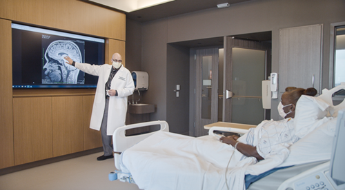 doctor showing patient screen of brain